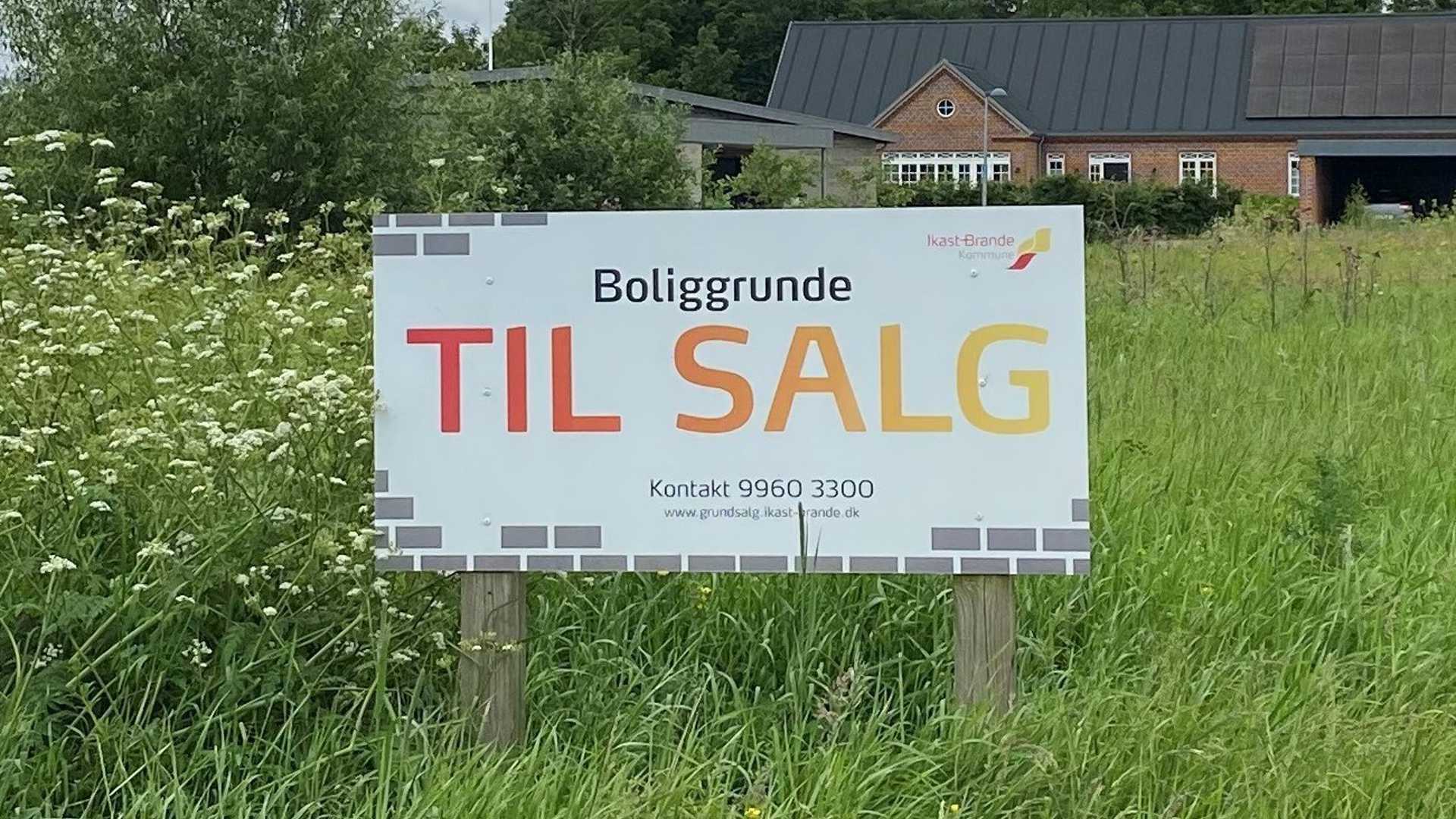 Billede. Til salg-skilt med kontaktoplysninger til kommunalt grundsalg