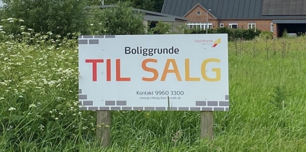Billede. Til salg-skilt med kontaktoplysninger til kommunalt grundsalg